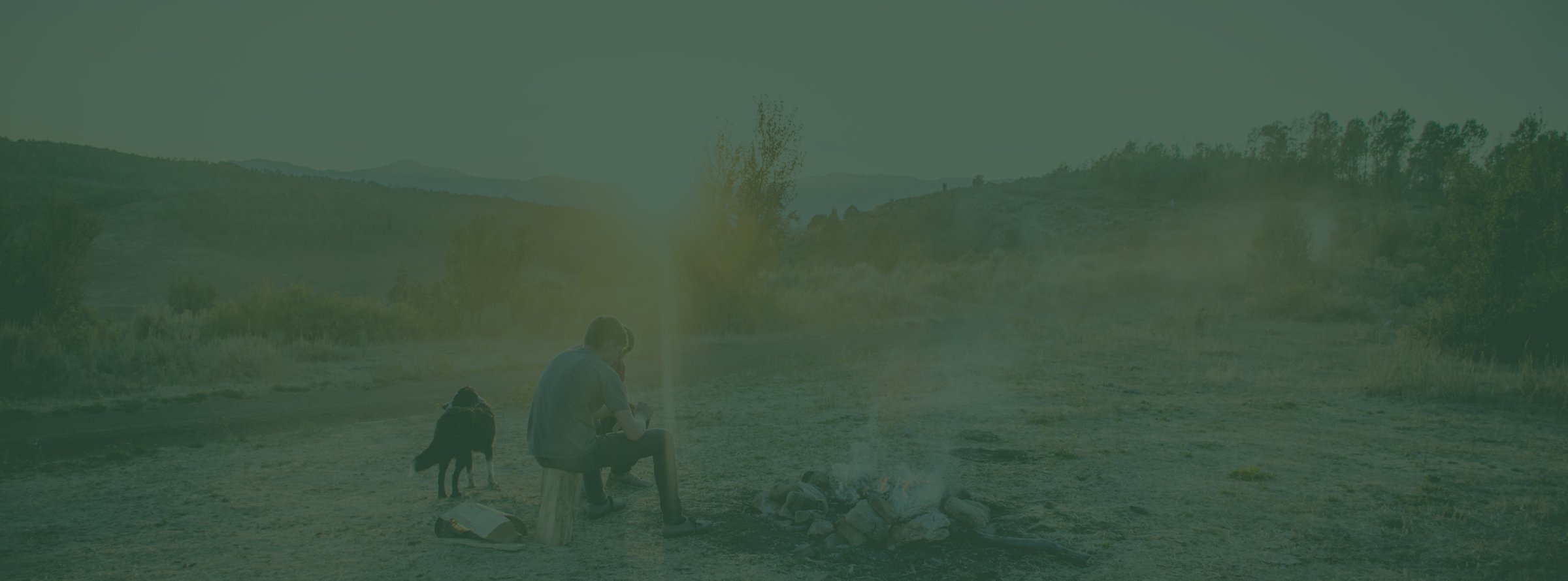 A woman sits in a rocking chair on a porch at sunset, holding a mug and looking out over a quiet suburban street.